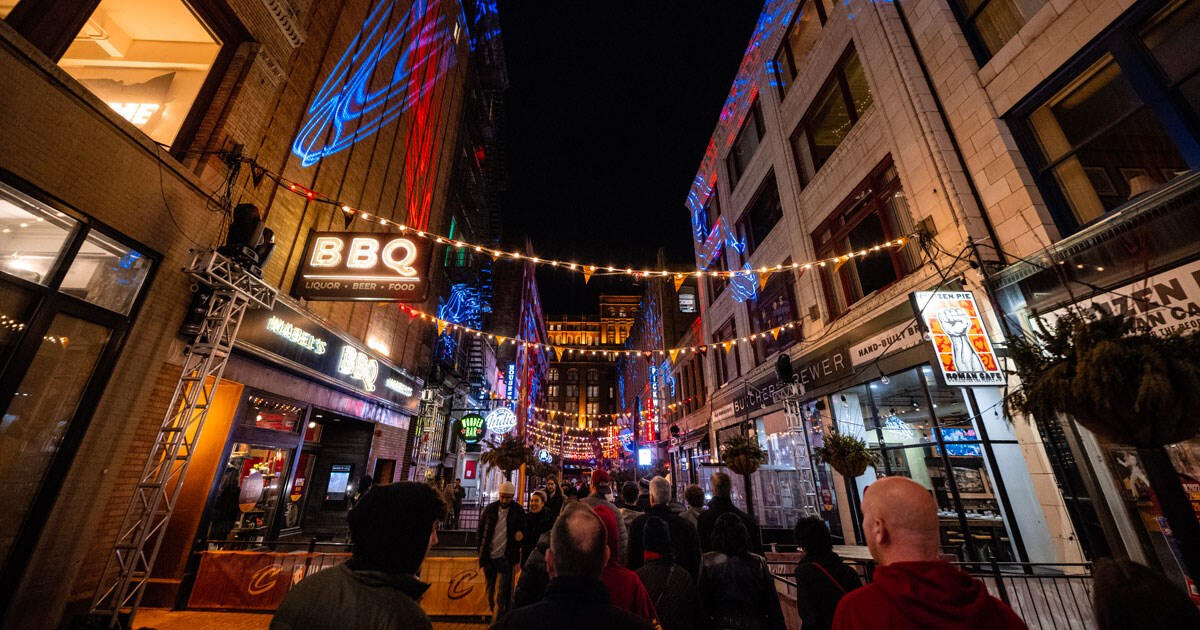 East 4th Street in downtown Cleveland Ohio pictured at night with a crowd of people.