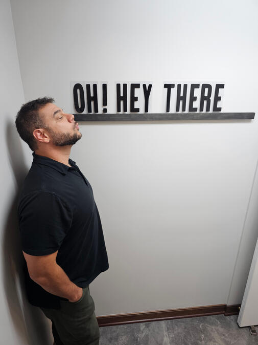 Limitless Real Estate Group agent Shane Shannon posing playfully beside an Oh! Hey There sign.