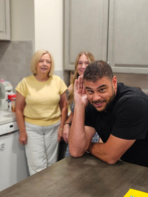 Shane Shannon leaning on a kitchen counter with Kathy Archer and Sarah Jobin Spaller behind him.