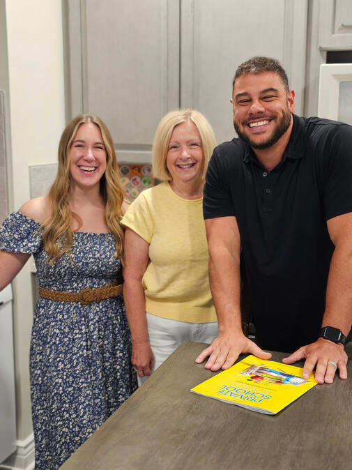 Shane Shannon smiling and leaning on a kitchen counter with Kathy Archer and Sarah Jobin Spaller next to him.